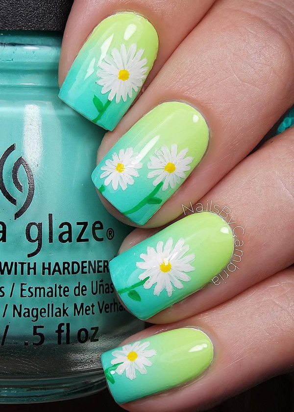 A very pretty spring nail art design. Starting with a green gradient base color, white flower details are then painted on top. This creates a warm and vibrant vibe for your nails.