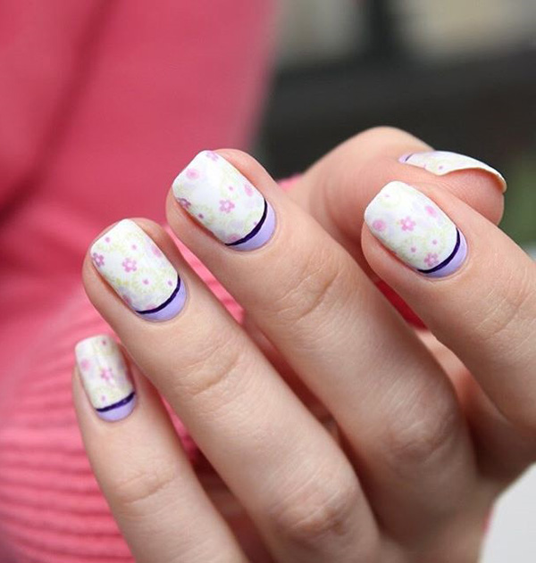 Pretty white and periwinkle spring nail art design. To add to the adorable design are cite little pink roses and leaves to signify the start of spring.