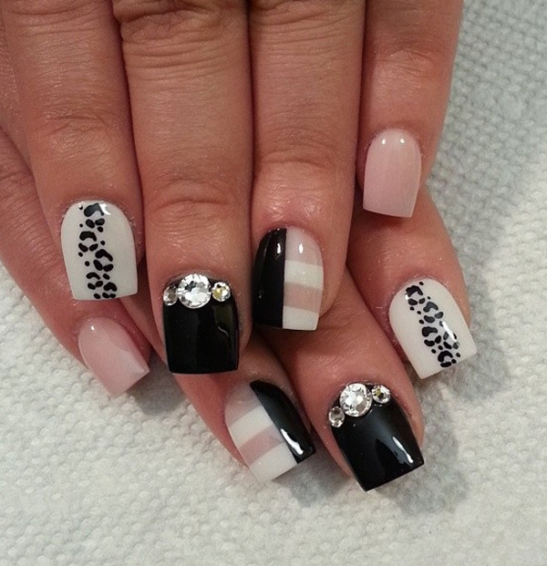 Black and white leopard nail art design with hints of nude nail polish.  The striped designs look perfect with the combination of the colors as well as the embellishments on top.