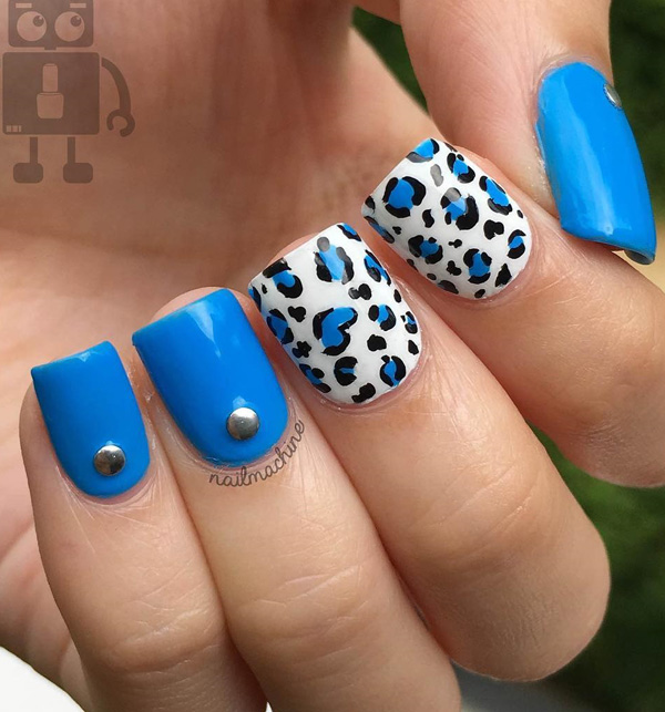 Blue and white leopard nail art design. An electrifying new look for leopard prints as the blue polish completely gives a new kind of life to the design. The silver embellishments on top also make the design look interesting.