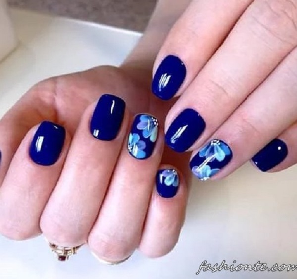 blue nail art design. The blue background is painted with light blue 