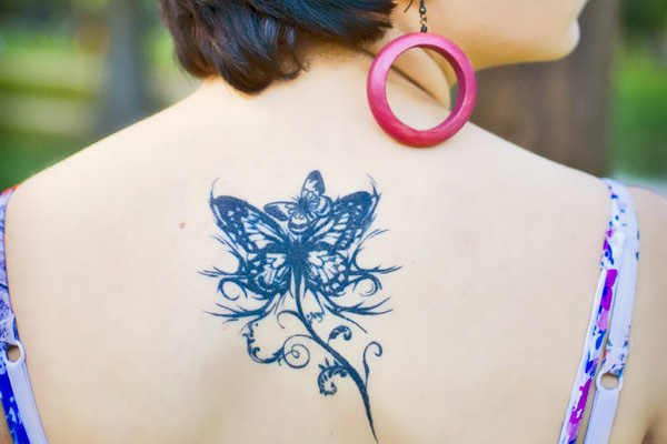 Tribal style butterfly tattoo on the back
